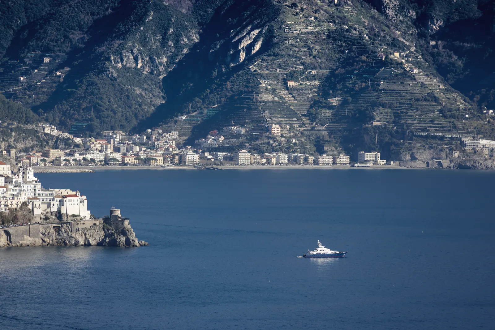 Yacht sailing near the picturesque Amalfi Coast, showcasing Mediterranean charm.