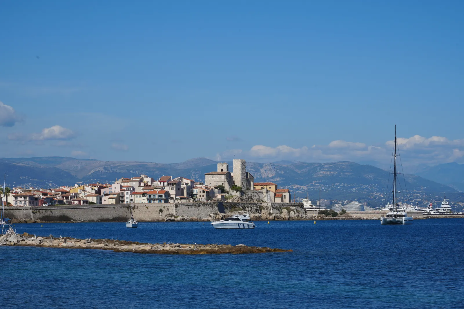 Antibes, France featuring the historic Old Town and peaceful marina under a clear blue sky.