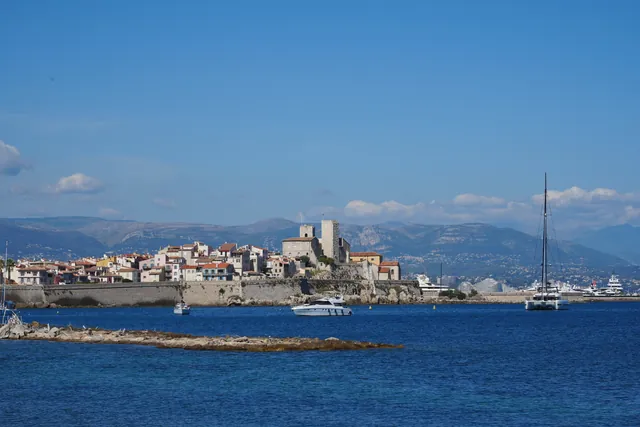 Antibes, France featuring the historic Old Town and peaceful marina under a clear blue sky.