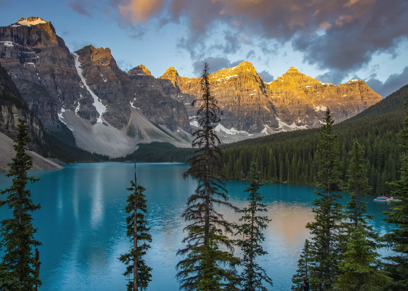A stunning view of Moraine Lake with mountains at sunset in Banff National Park, Canada.