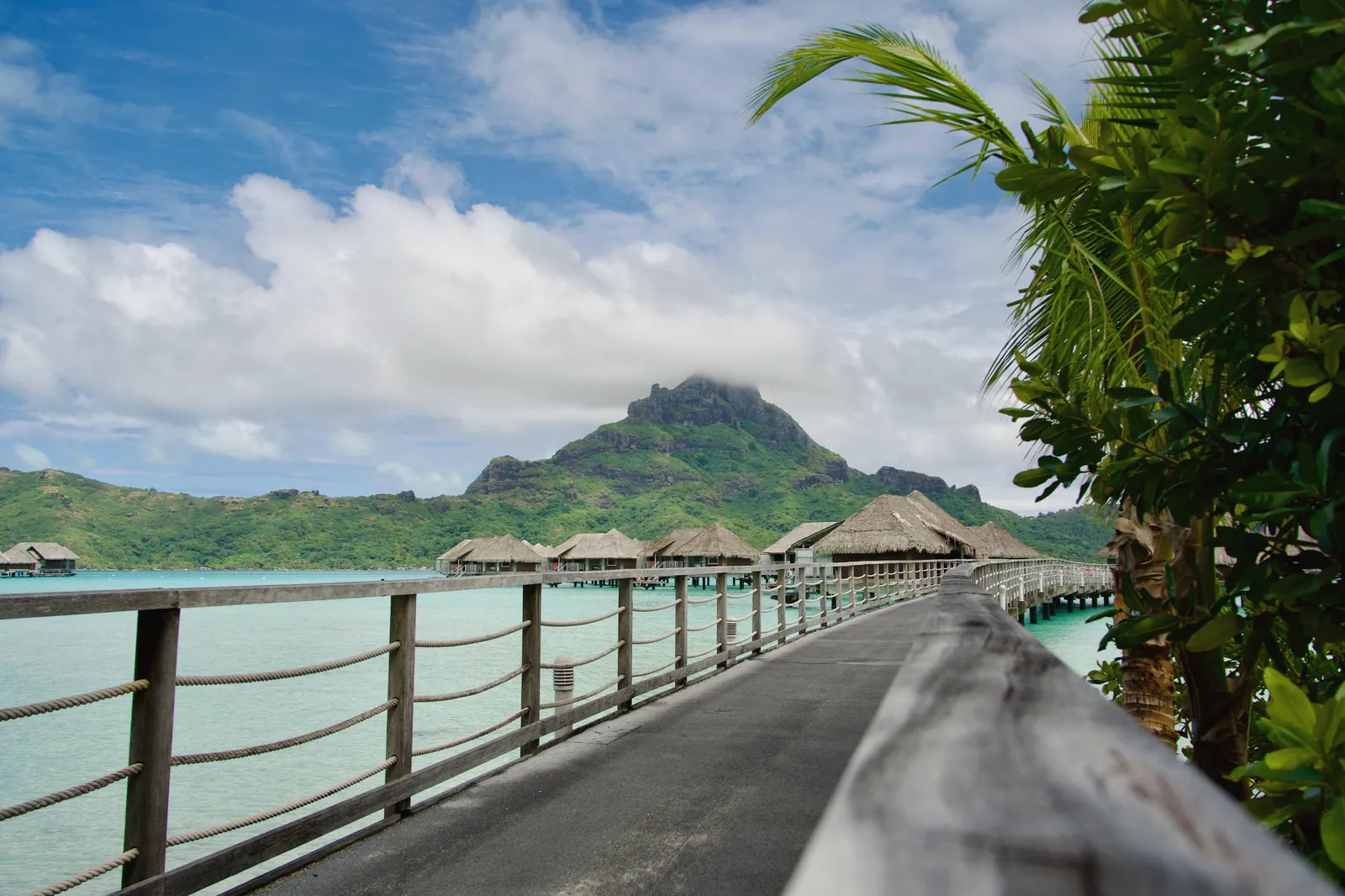 Stunning view of overwater bungalows with a mountain backdrop in Bora Bora, French Polynesia.