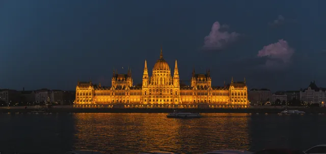 Night view of the glowing Hungarian Parliament Building reflected in the Danube River.