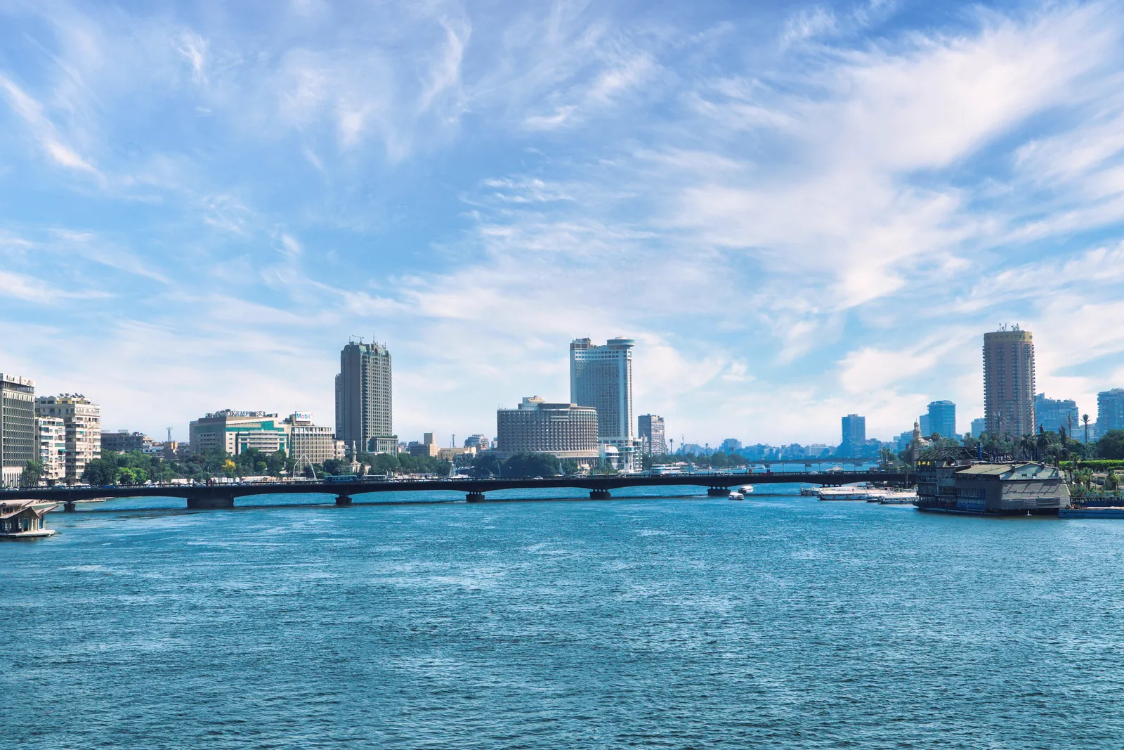 Discover the stunning Cairo skyline with the serene Nile River and a clear blue sky backdrop.