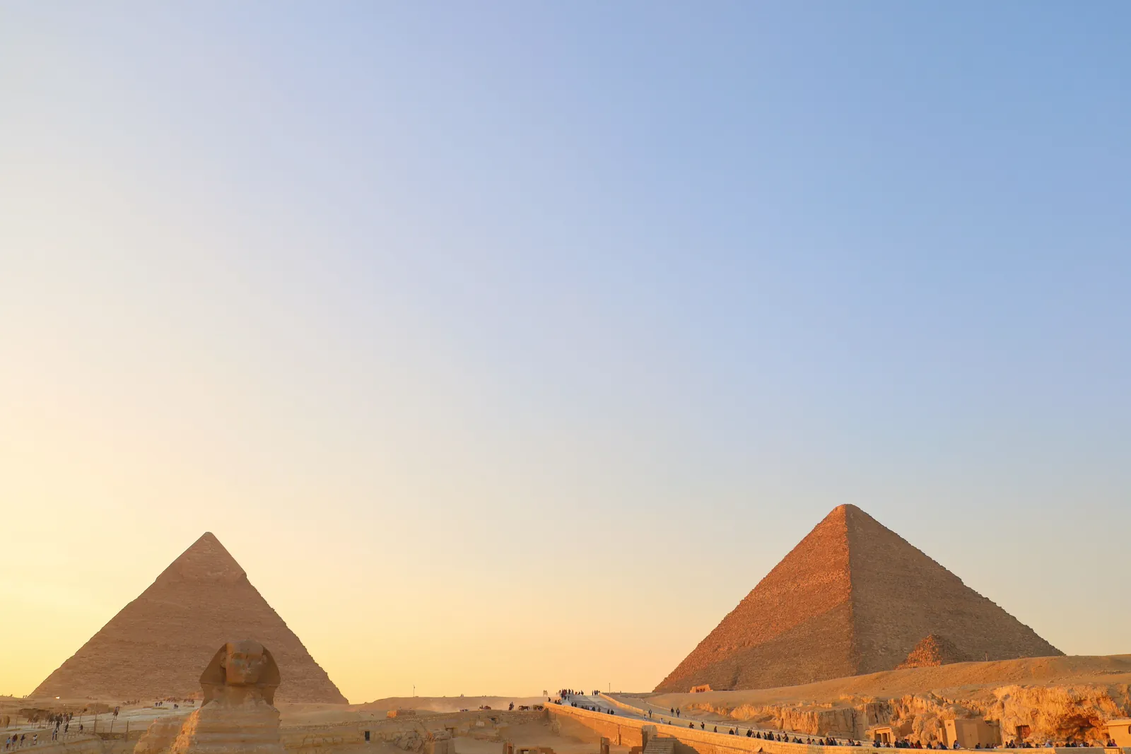 A stunning view of the Giza pyramids and Sphinx during sunset in Cairo, Egypt.