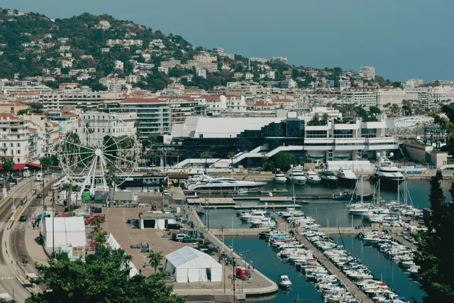 Scenic aerial shot of Cannes harbor with yachts and cityscape, capturing the essence of the French Riviera.