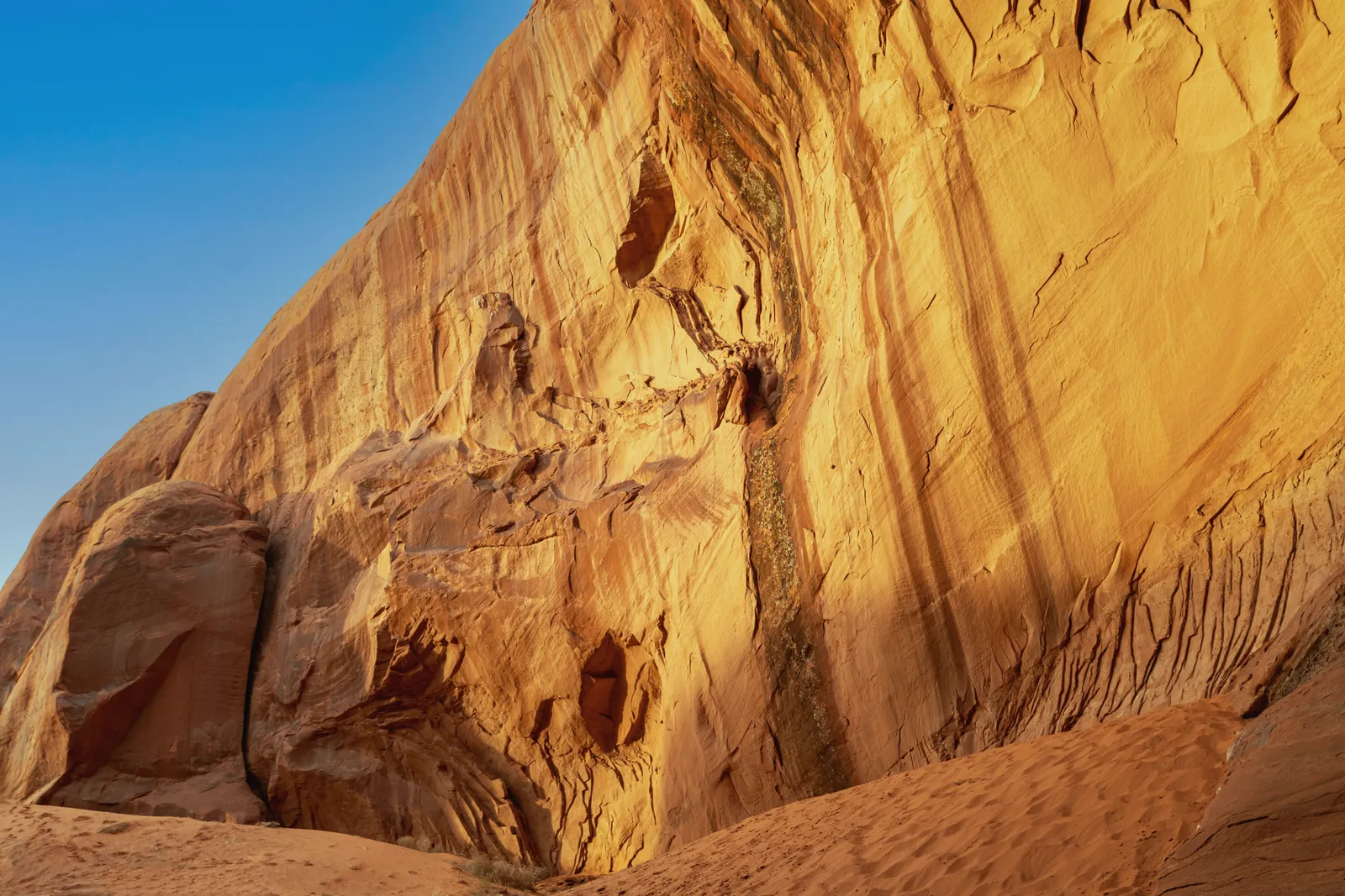 Majestic red rock cliffs basking in sunlight, desert ambiance captured in golden hues.
