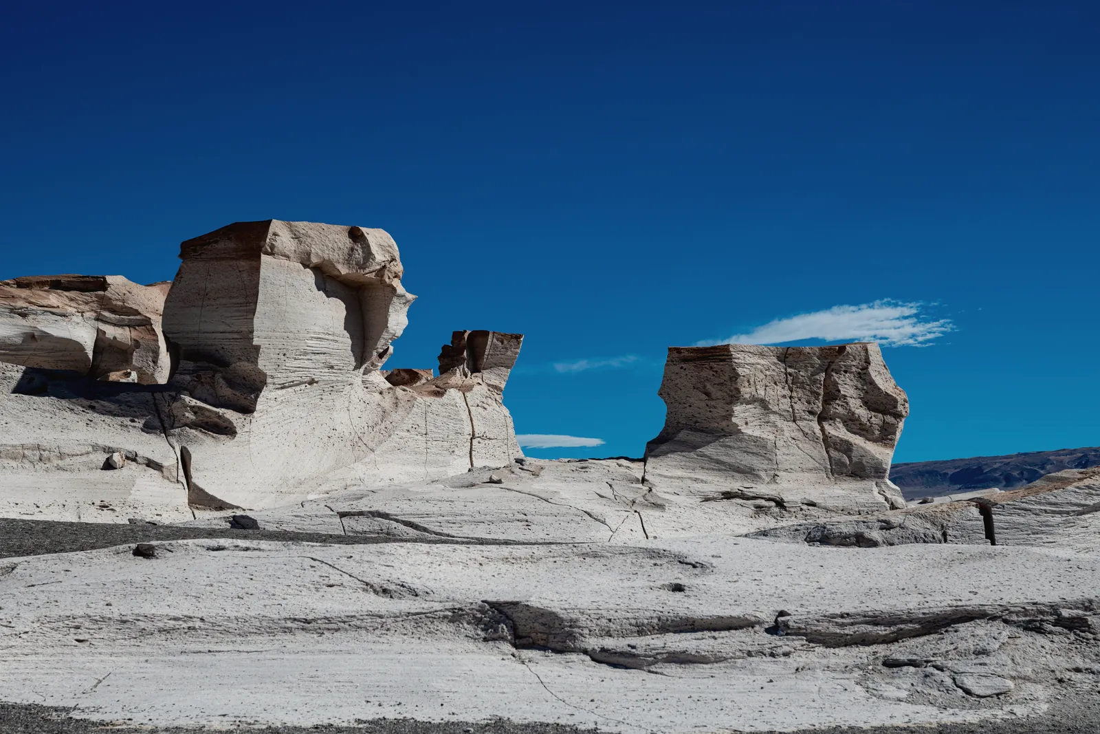 Unique rock formations in a desert landscape under a bright blue sky.