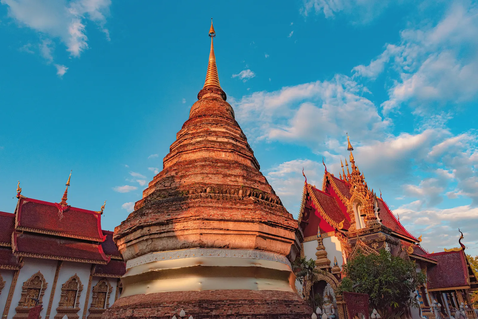 Stunning view of a traditional Buddhist temple against a bright blue sky in Chiang Mai, Thailand.