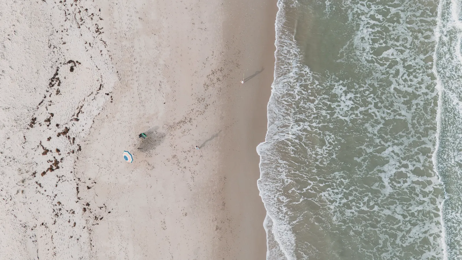 Aerial shot of Fort Pierce beach with gentle waves and sandy shore, showcasing a peaceful coastal scene.
