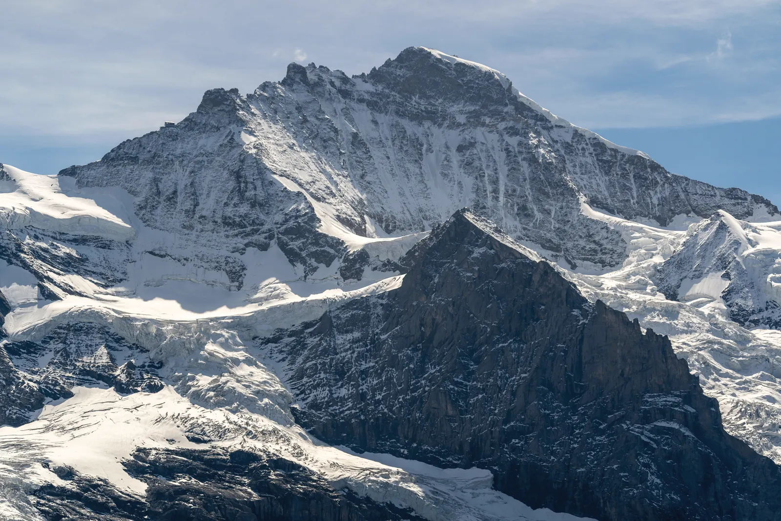 Breathtaking view of snow-capped mountains in the Swiss Alps under a clear blue sky.