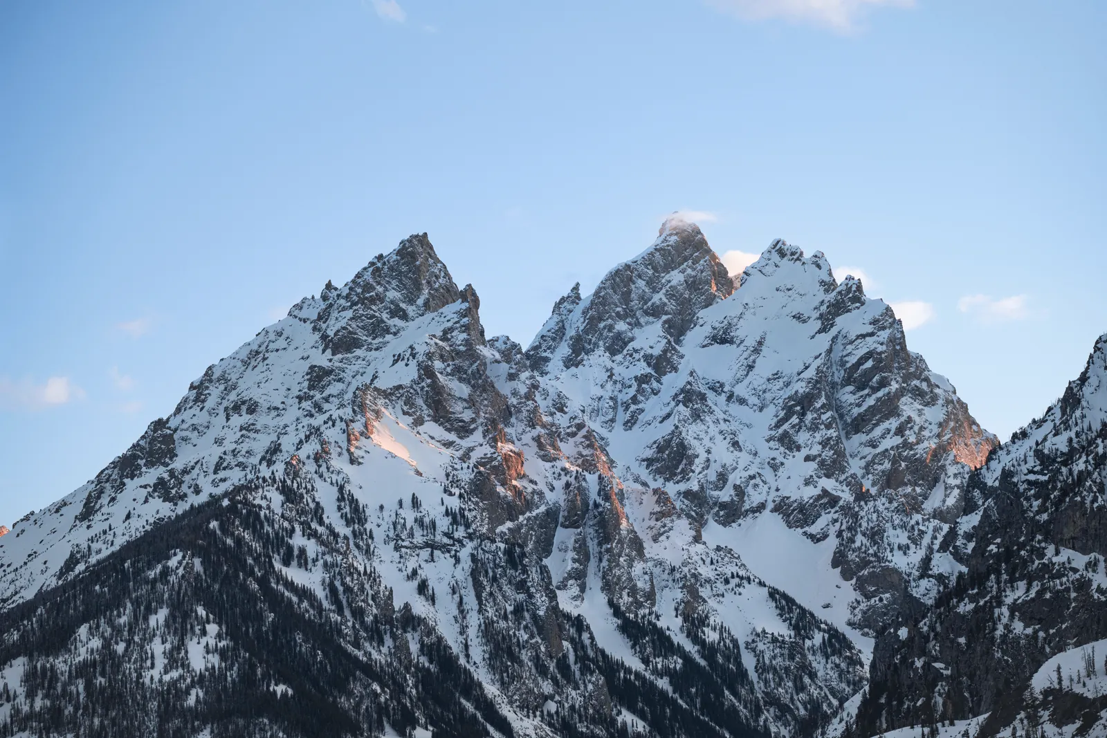 Breathtaking view of the snowcapped Teton Range under a clear blue sky in Wyoming, USA.