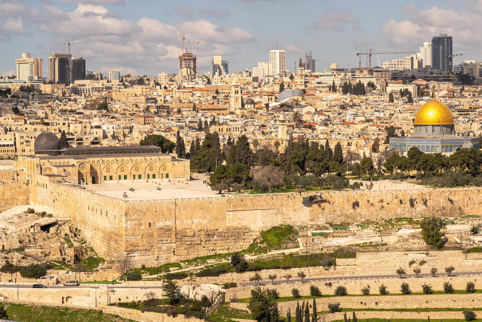 A breathtaking view of Jerusalem featuring Al-Aqsa Mosque and the Dome of the Rock under a bright sky.