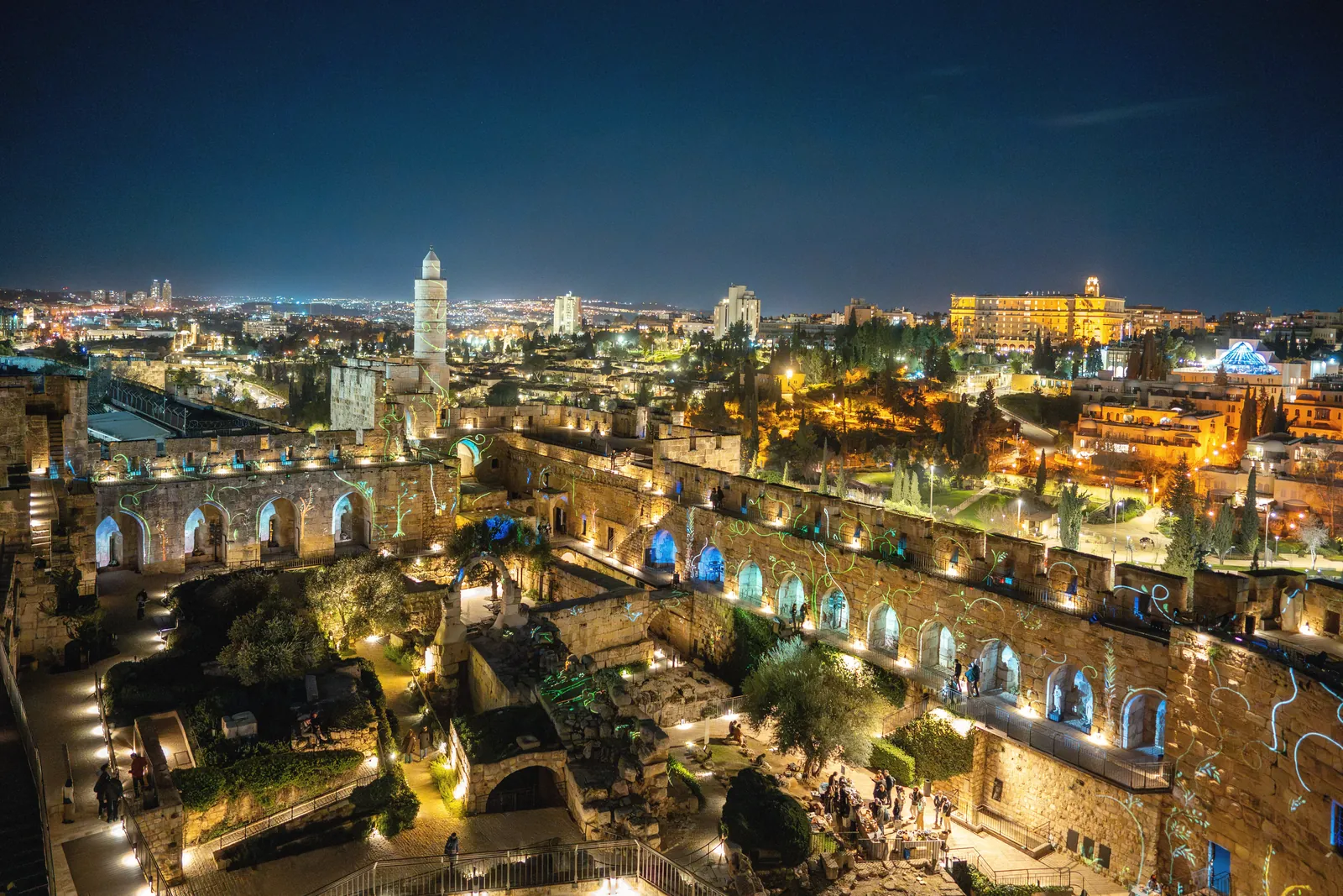 A stunning nighttime view of the illuminated Tower of David and Jerusalem cityscape, showcasing historical architecture.