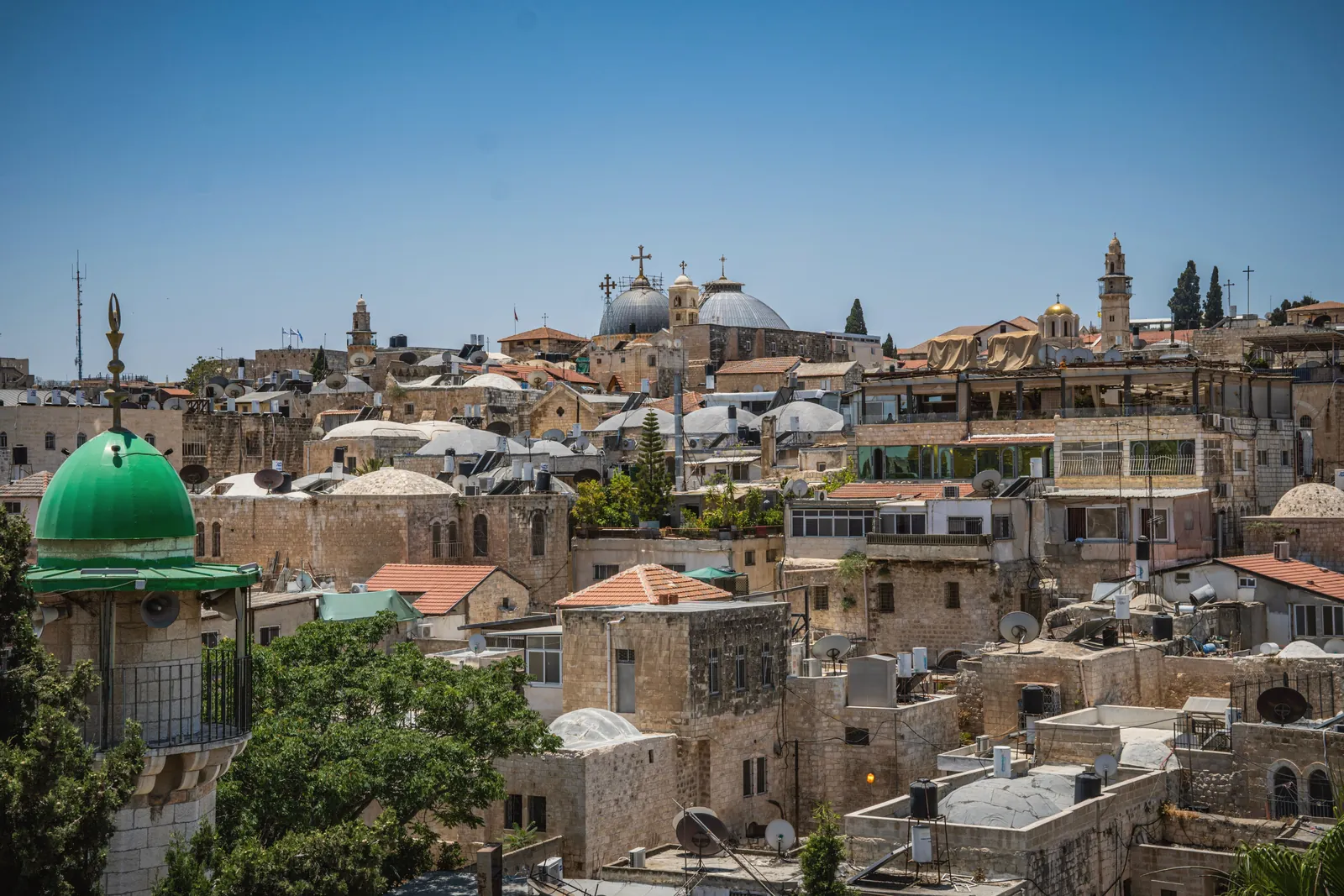 A vibrant view of Jerusalem's ancient architecture under a clear blue sky.
