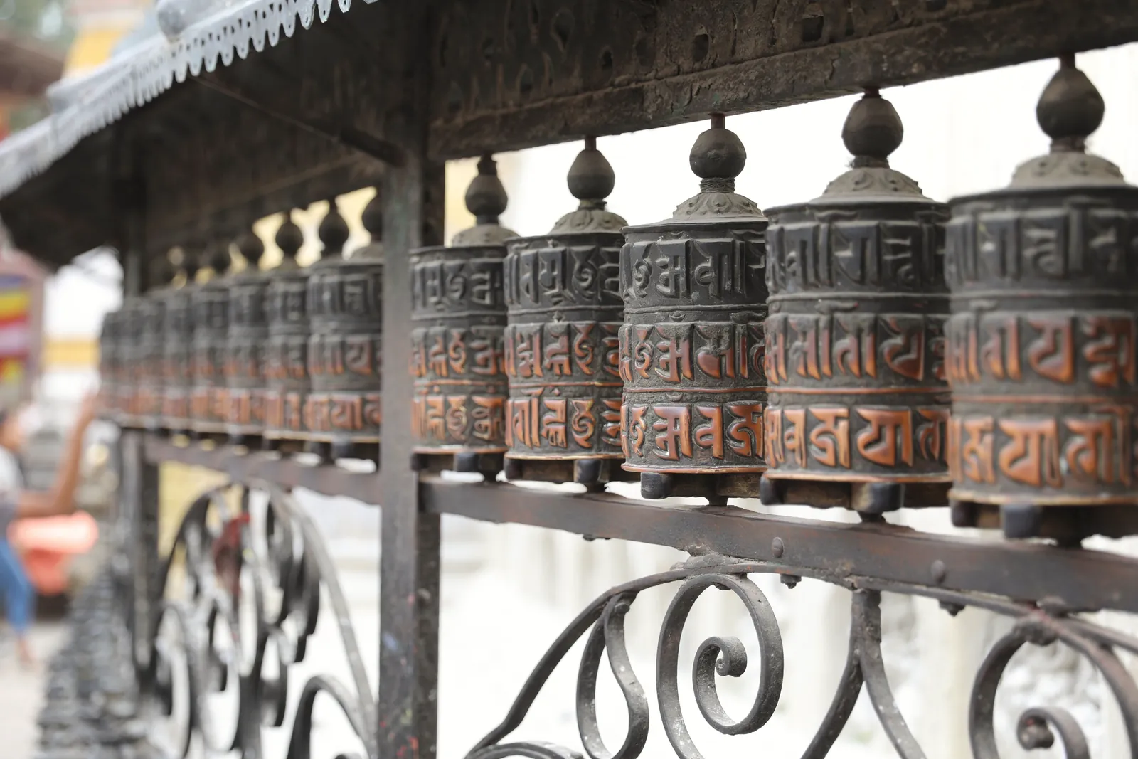 Close-up of ornate prayer wheels in a Buddhist temple, showcasing craftsmanship.