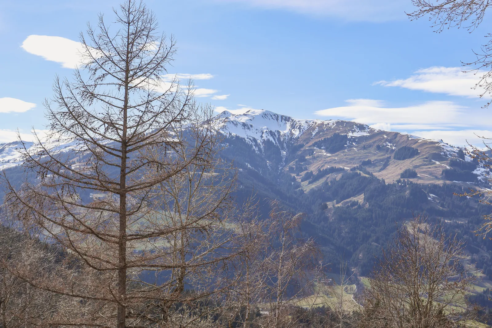 A serene mountain landscape in Aurach bei Kitzbühel, Austria with a clear blue sky.