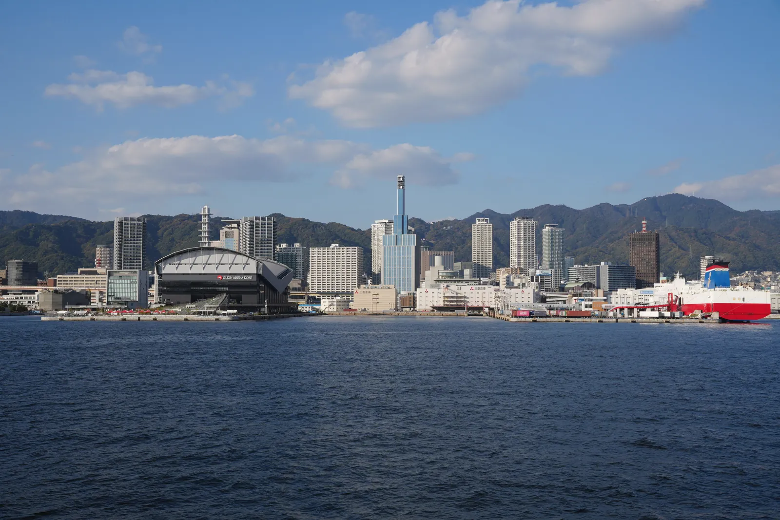 Skyline view of Kobe, Japan featuring the port and cityscape against clear blue skies.
