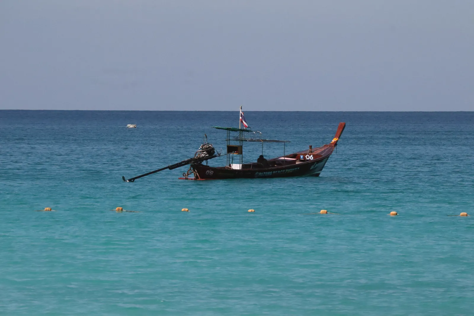 A peaceful longtail boat floating on turquoise waters in Thailand, capturing the essence of calmness and beauty.