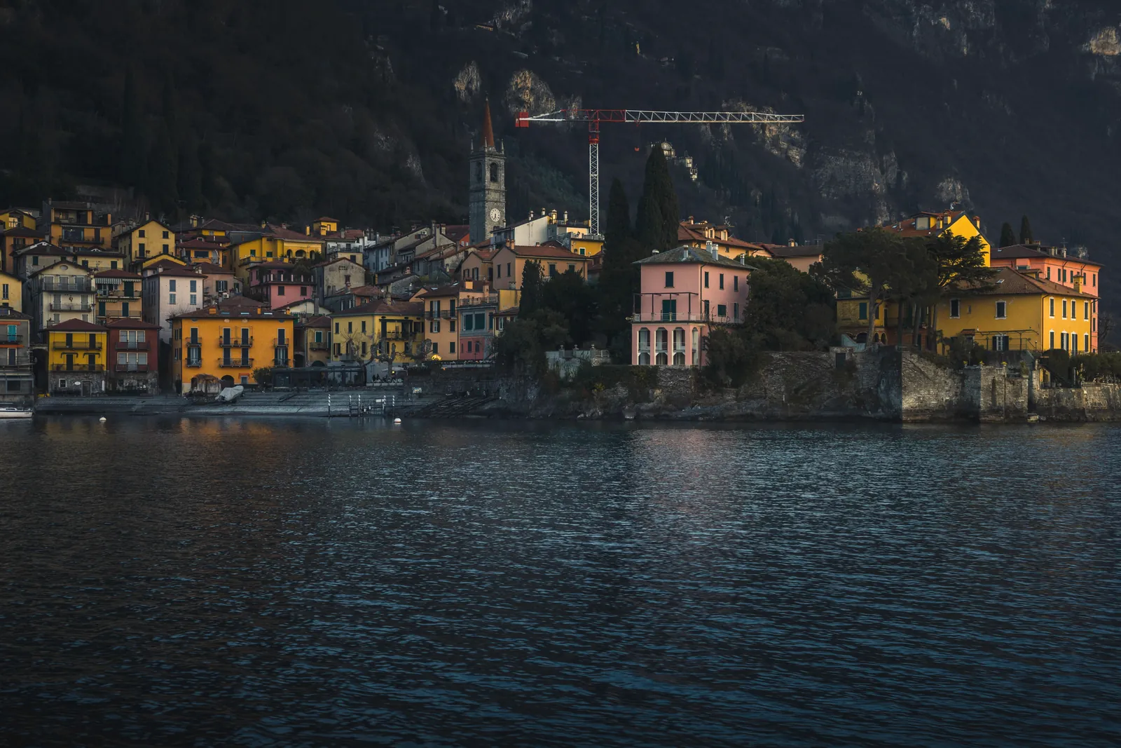 A picturesque view of colorful village buildings by Lake Como, Italy, with serene waters.