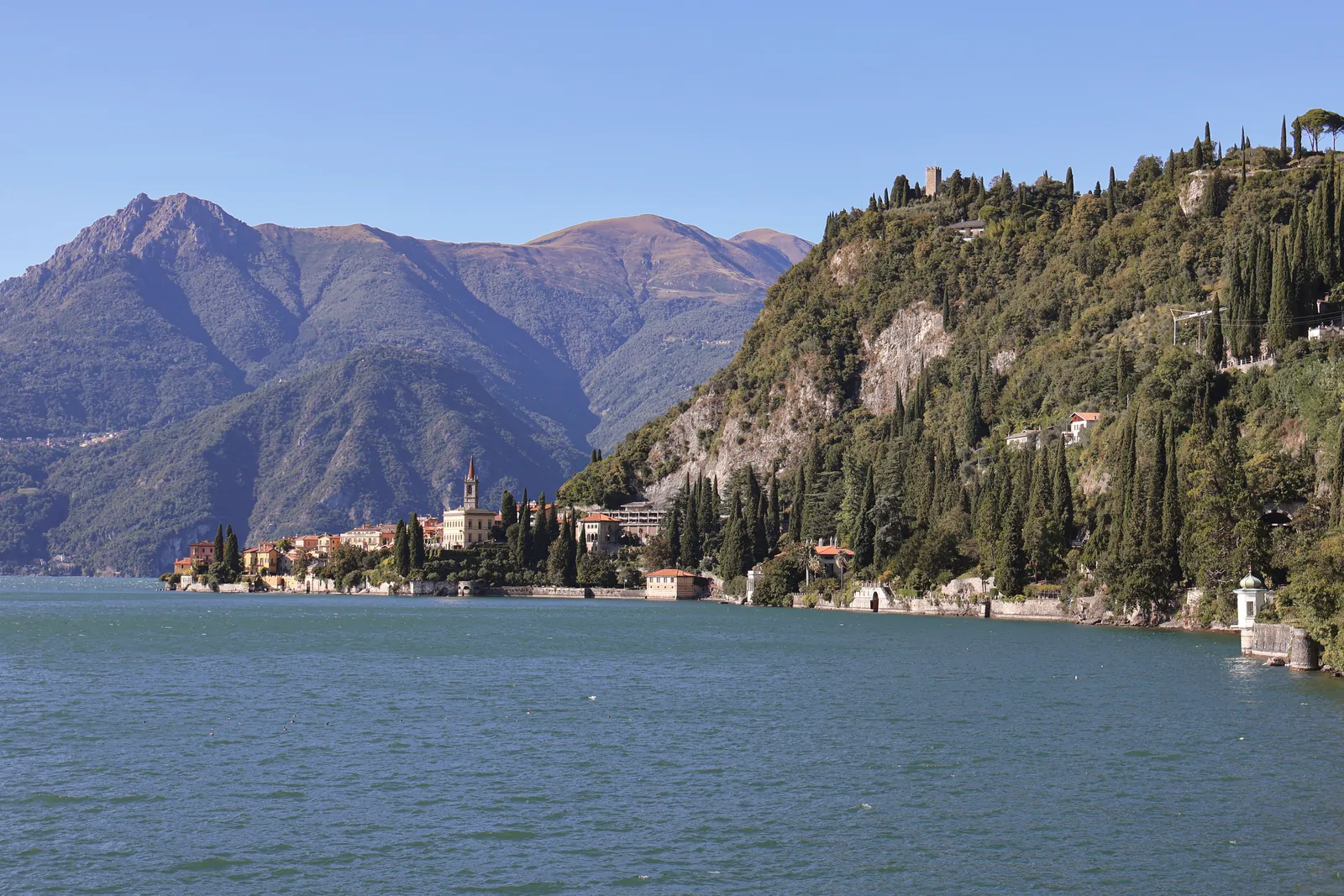 Scenic view of Lake Como with its calm waters and surrounding mountains in Varenna, Italy.