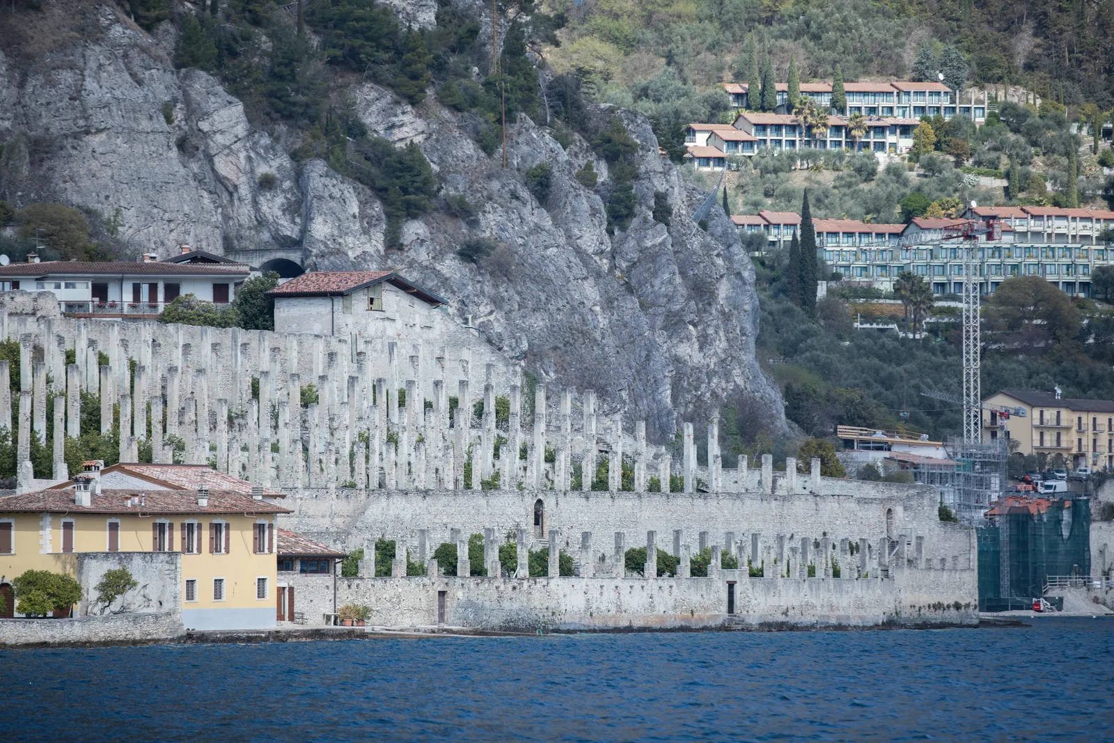 Scenic view of Lake Como with unique architecture and rocky backdrop, capturing Italy's charm.