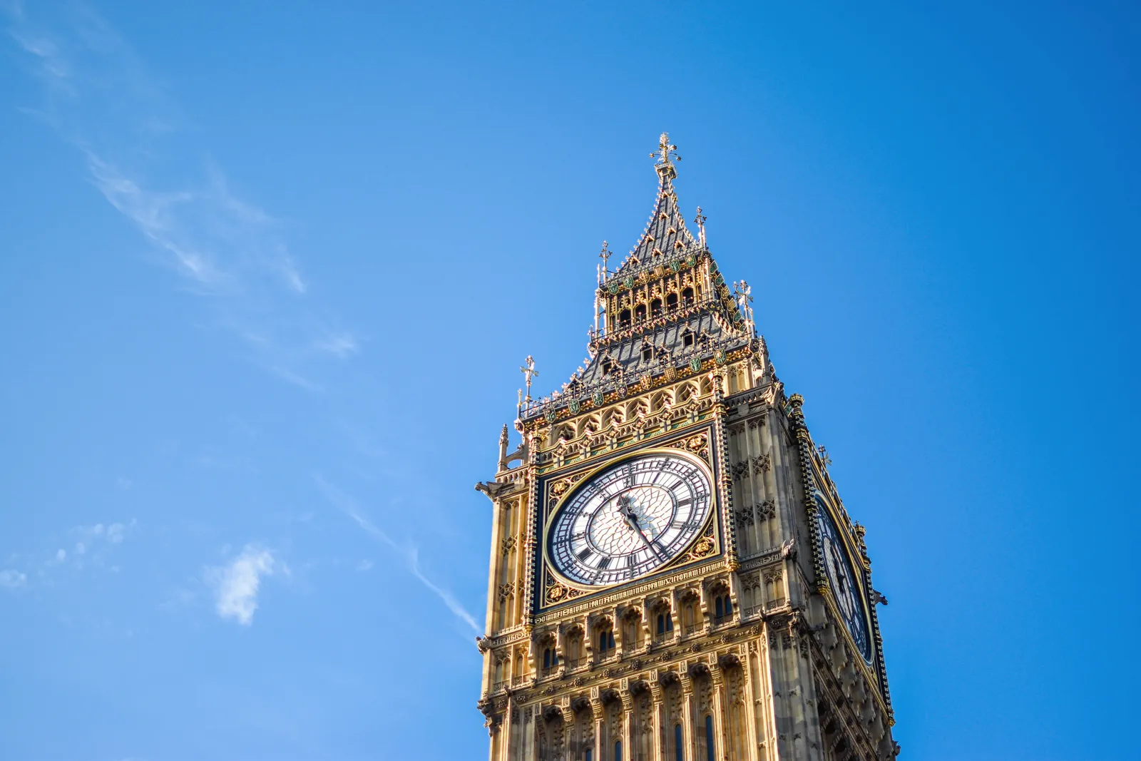 Stunning low angle view of Big Ben clock tower with a clear blue sky background, London landmark.