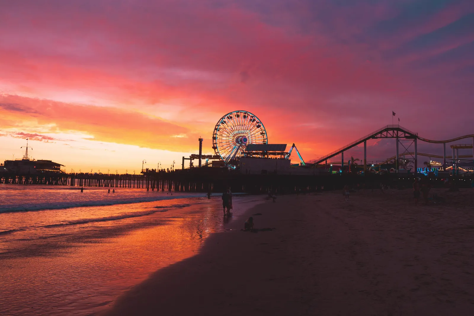 Breathtaking sunset over Santa Monica Pier with illuminated Ferris wheel and vibrant skies.