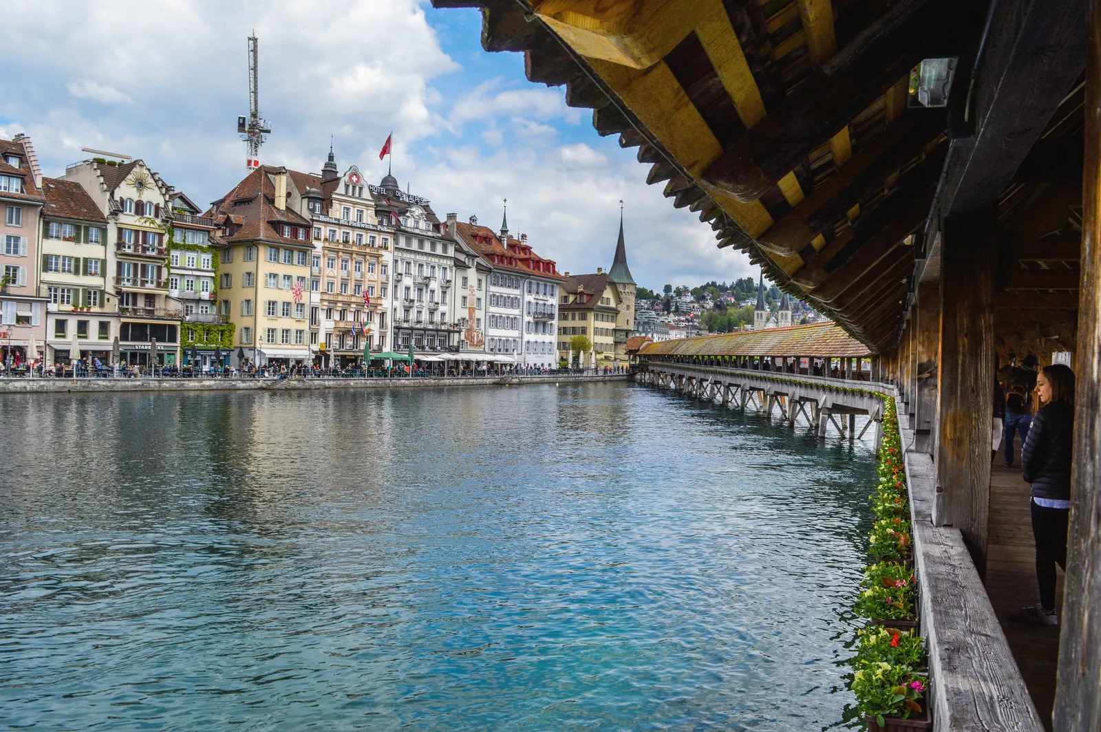 Exterior of aged wooden bridge crossing river channel and leading to historic buildings in old town in daytime