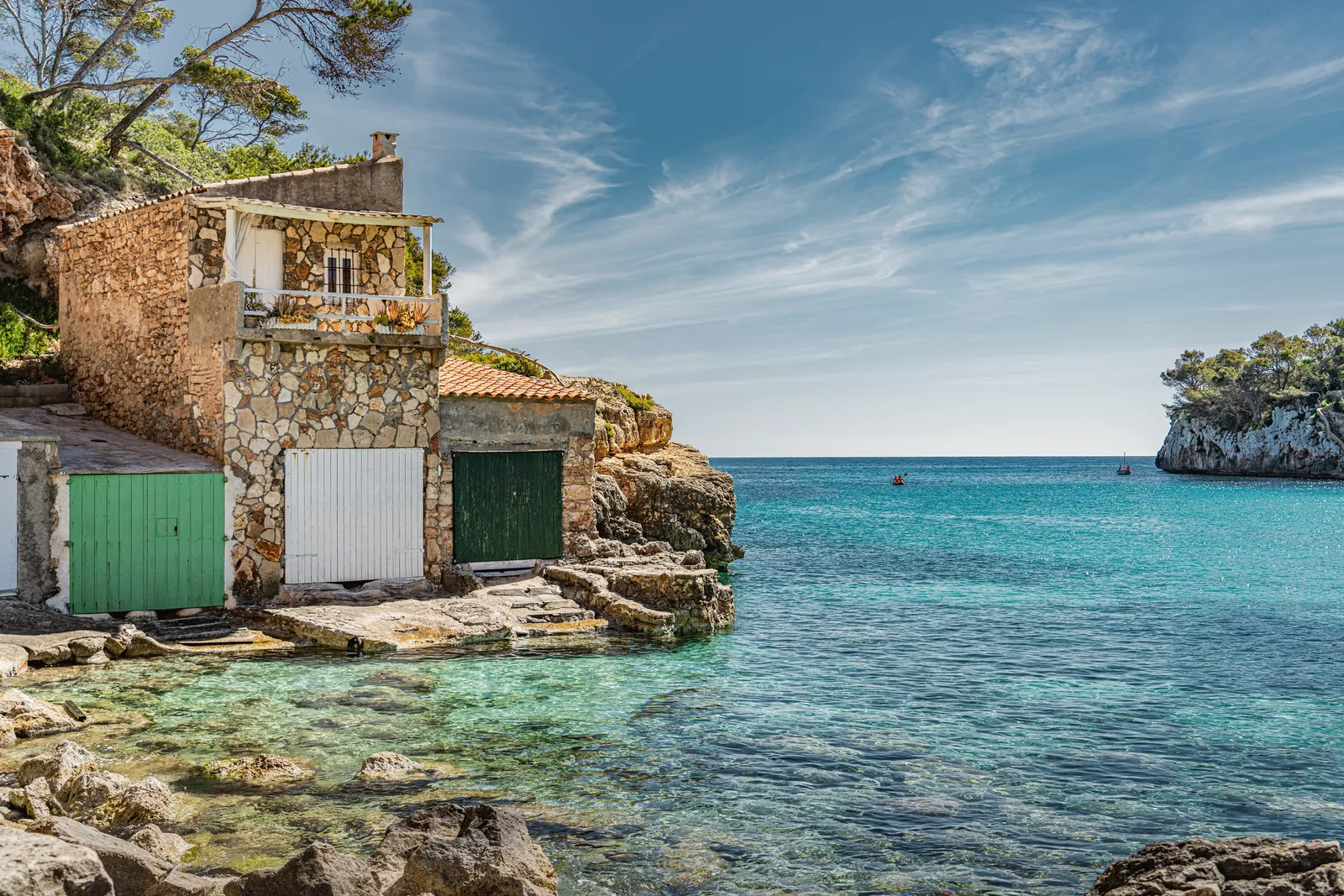 Charming stone house by clear turquoise waters in Palma, Spain, ideal for tranquil getaways.