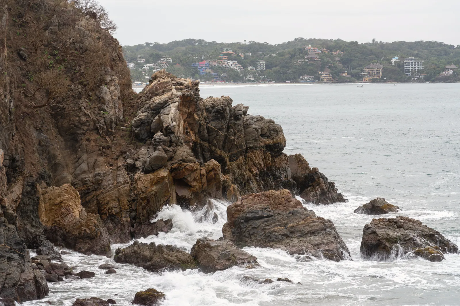 Dramatic coastal cliffs with waves crashing, offering a stunning oceanfront view.