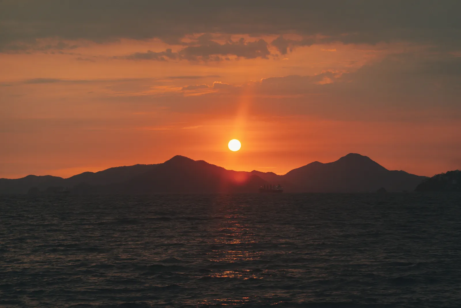 Stunning sunset view over the ocean with mountains in Manzanillo, Mexico.