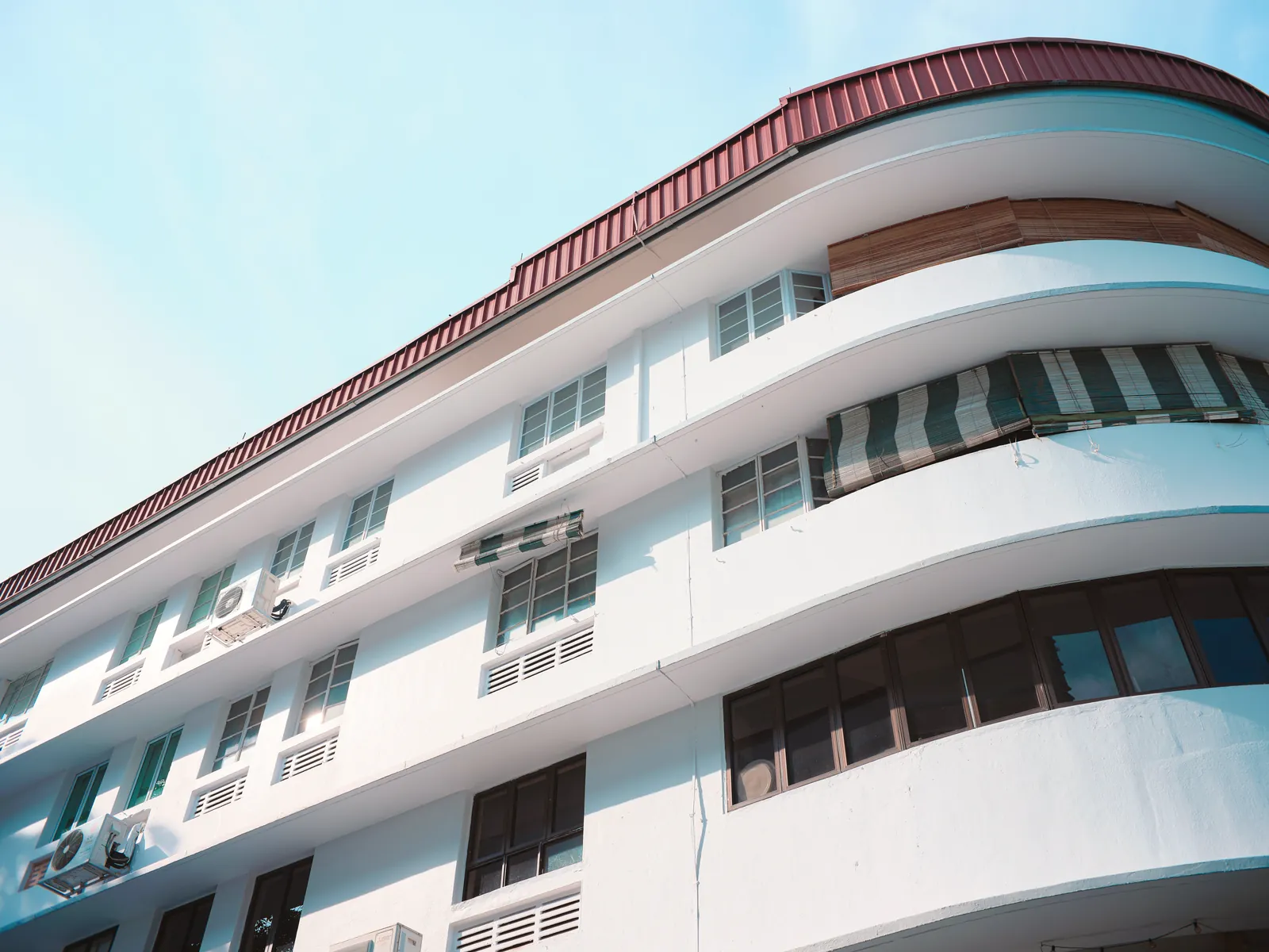 A modern architectural building with curved lines against a clear, bright sky, showcasing urban design.