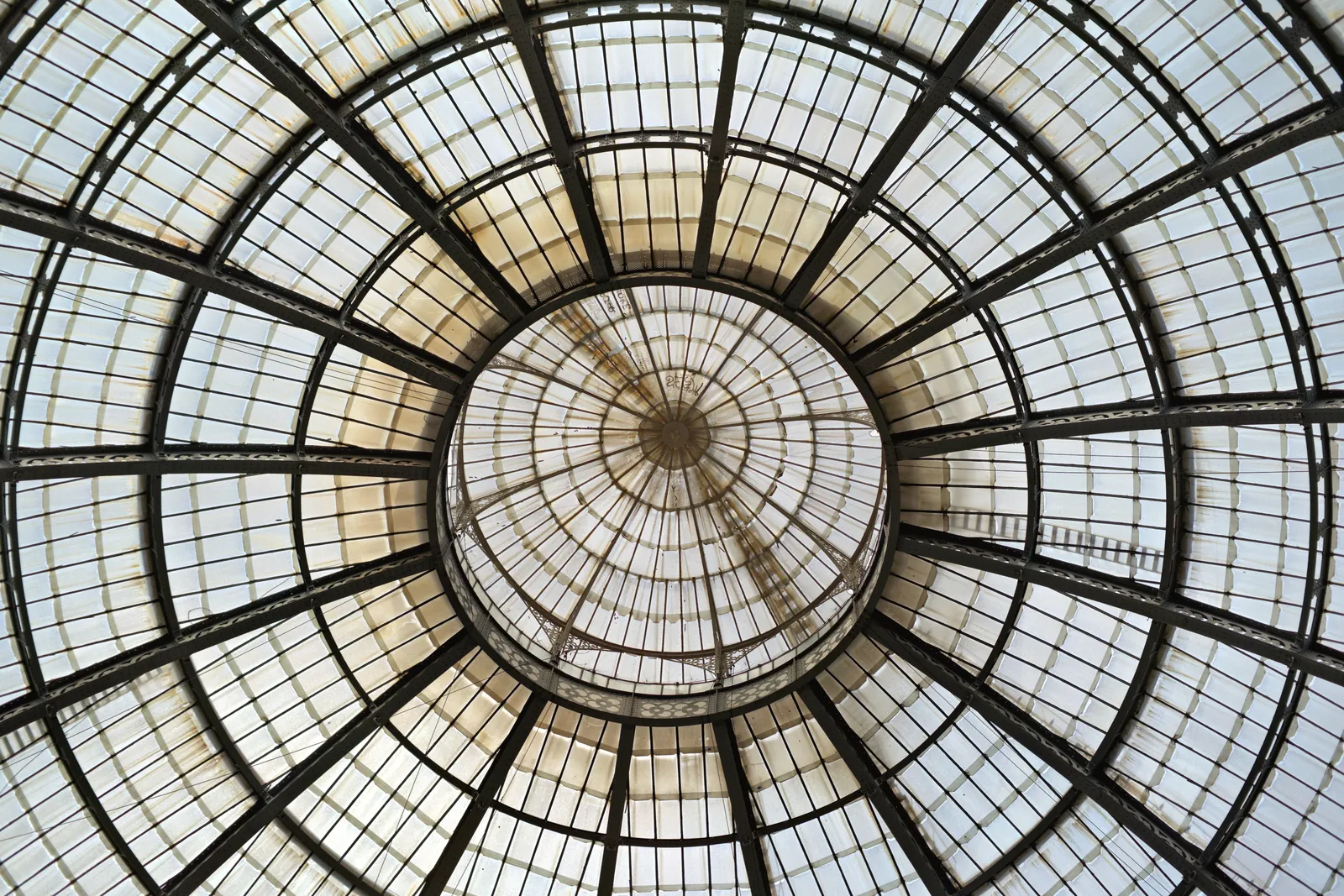 Intricate glass dome ceiling of the Galleria Vittorio Emanuele II in Milan, Italy, showcasing architectural beauty.