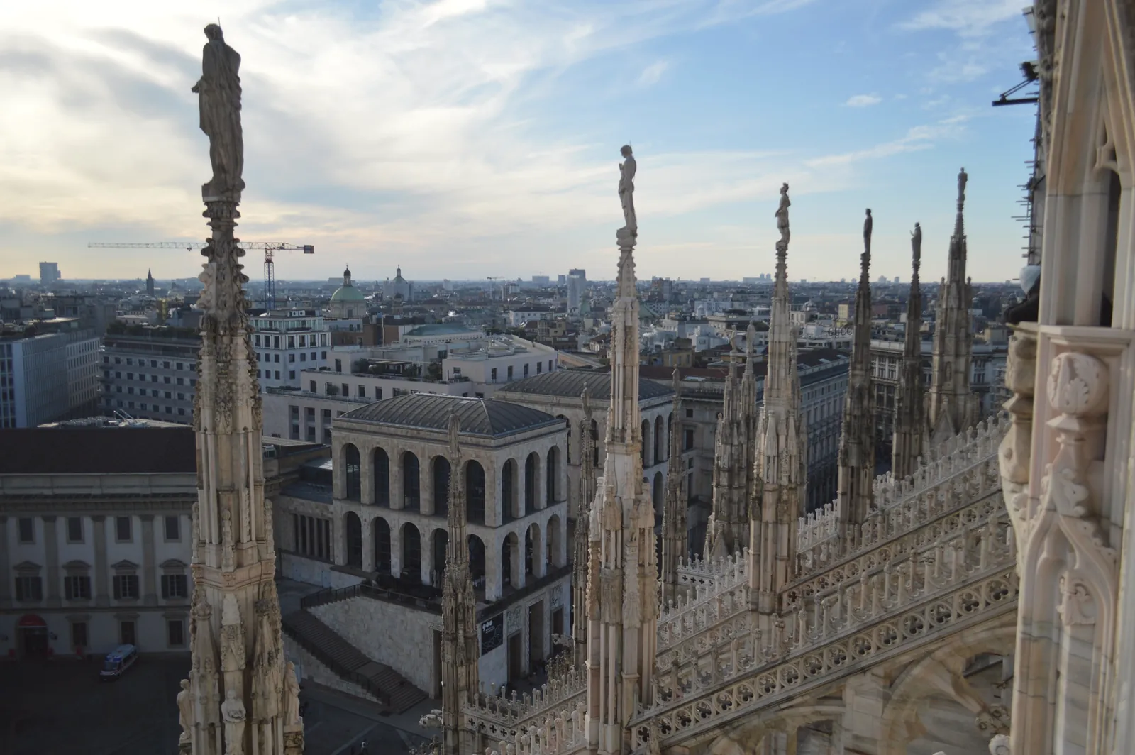 Skyline view from Milan Cathedral rooftop showcasing cityscape and architectural details.