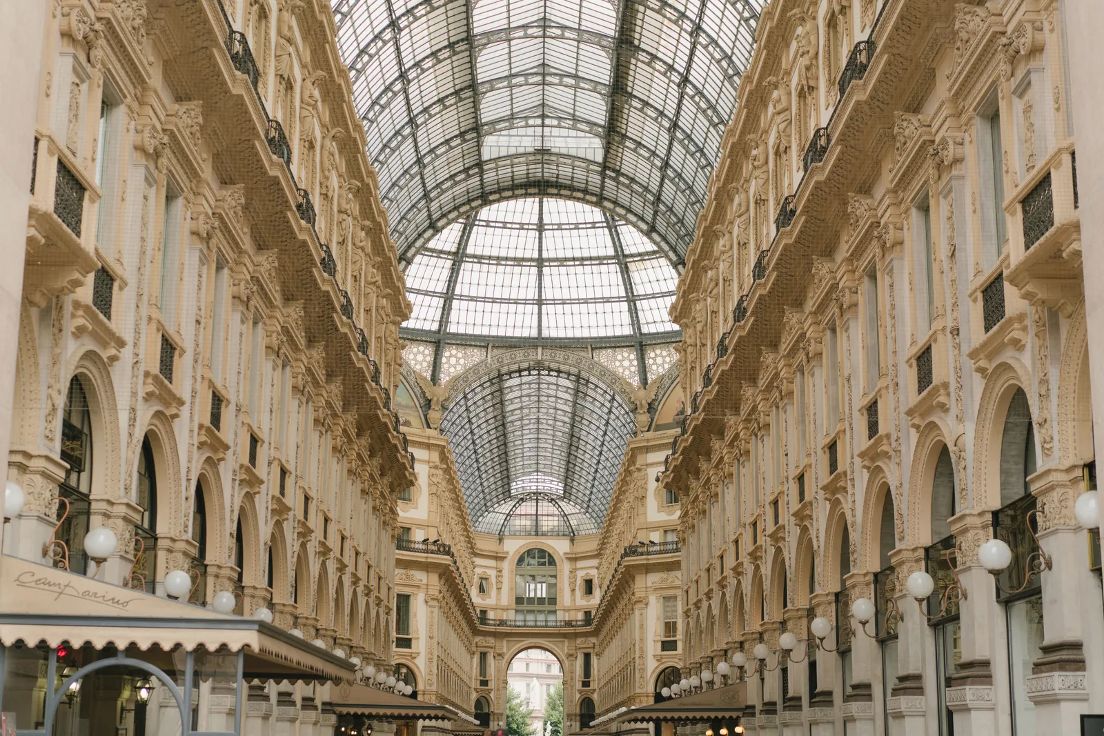 Low angle of aged stone shopping gallery with arching glass roof and ornamental walls
