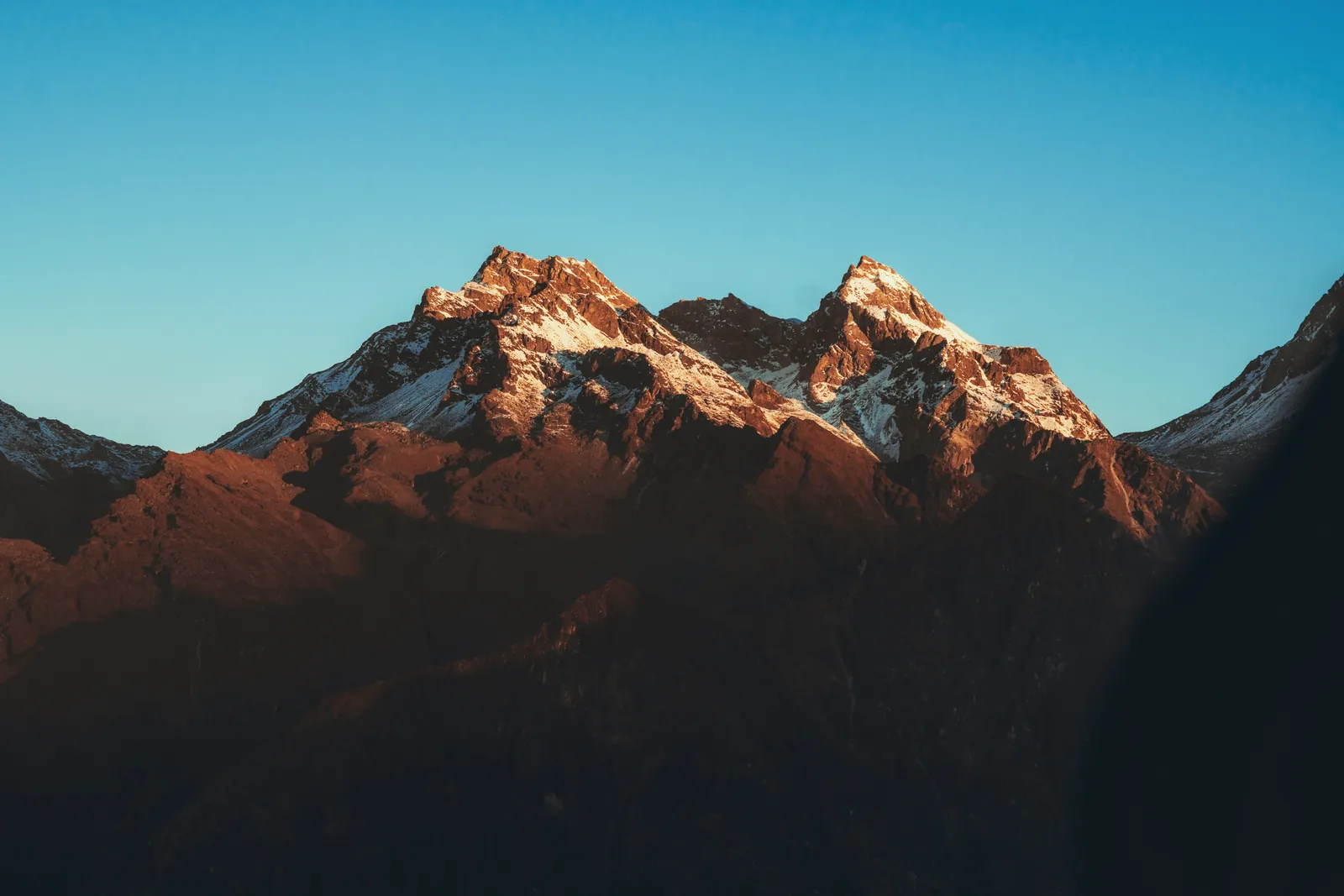 Stunning view of Himalayan mountain peaks in Nepal illuminated by warm sunrise light.
