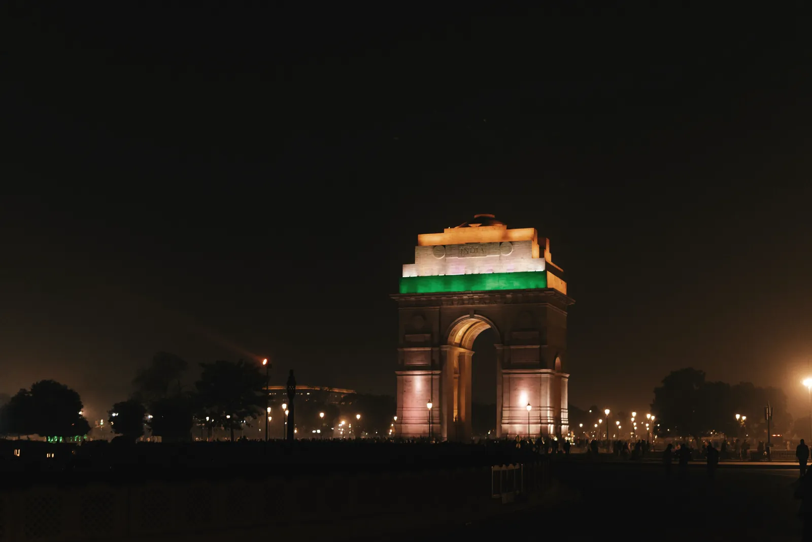 India Gate, New Delhi, beautifully illuminated at night, showcasing vibrant colors and architectural beauty.