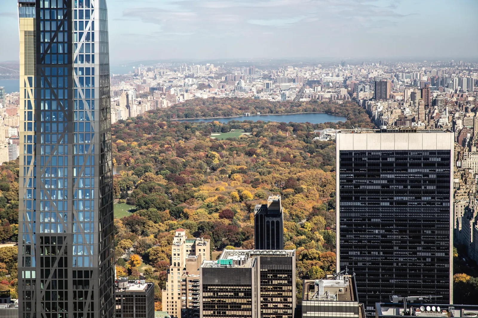 Stunning aerial view of NYC's Central Park with autumn foliage and skyscrapers.