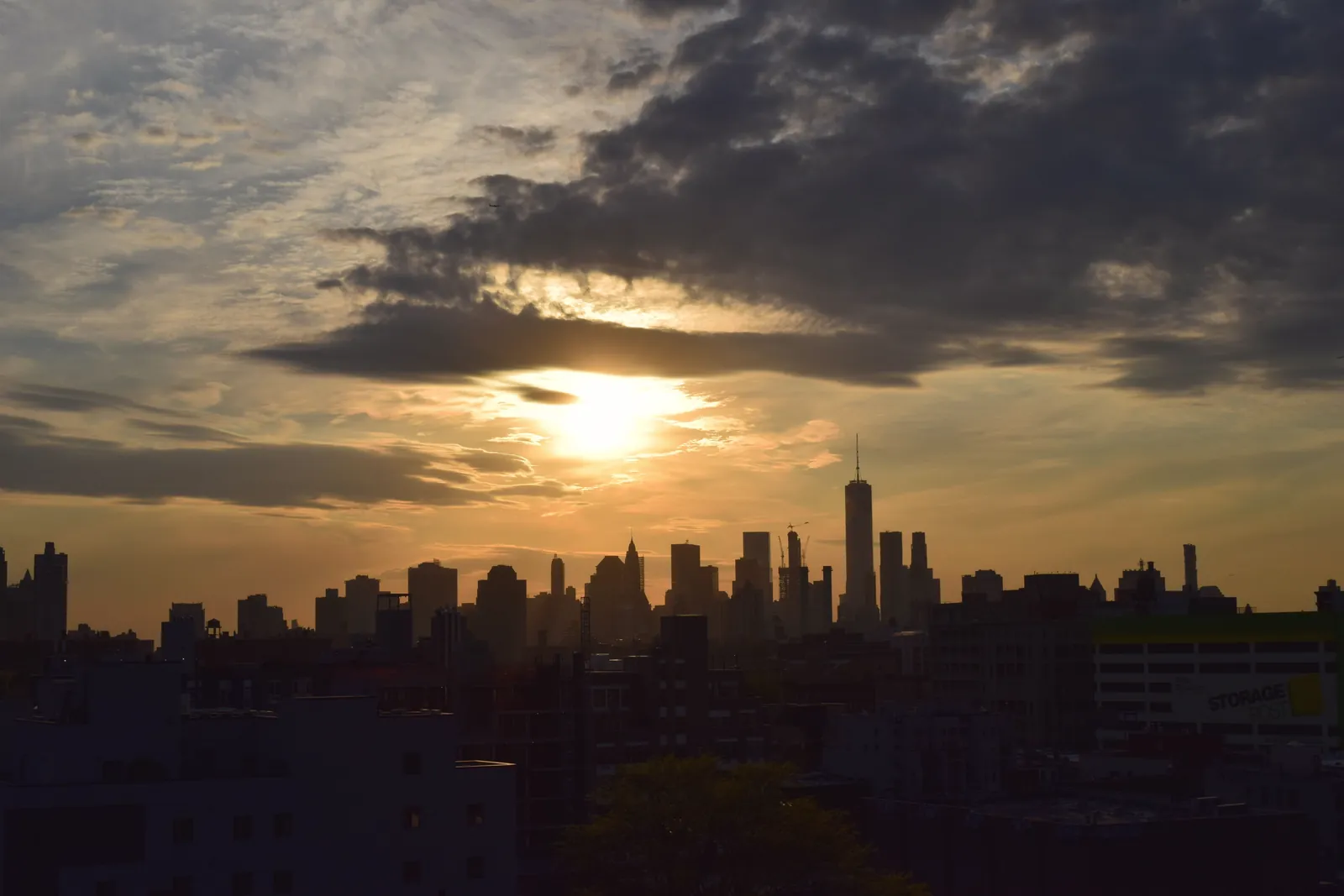 Silhouette of the New York City skyline against a vibrant sunset sky.