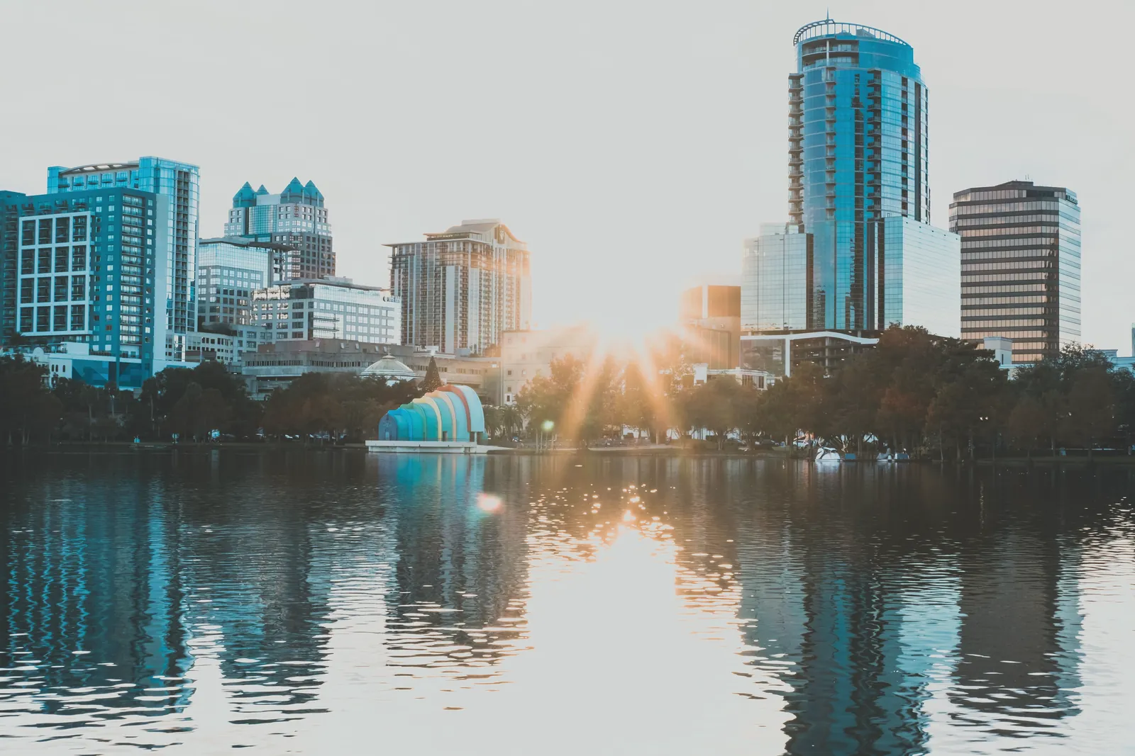 Capture of Orlando's skyline reflecting in a lake during sunrise, showcasing urban beauty and tranquility.