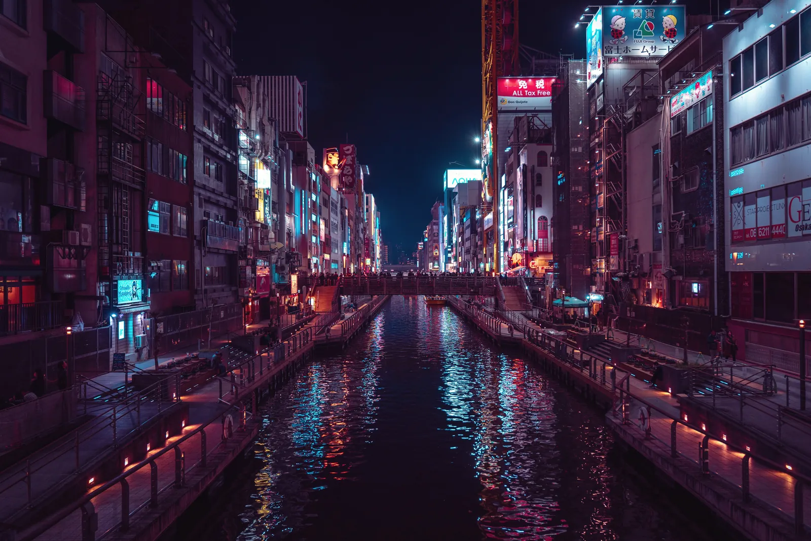 Vibrant night view of Dotonbori Canal in Osaka, Japan, showcasing illuminated city lights.
