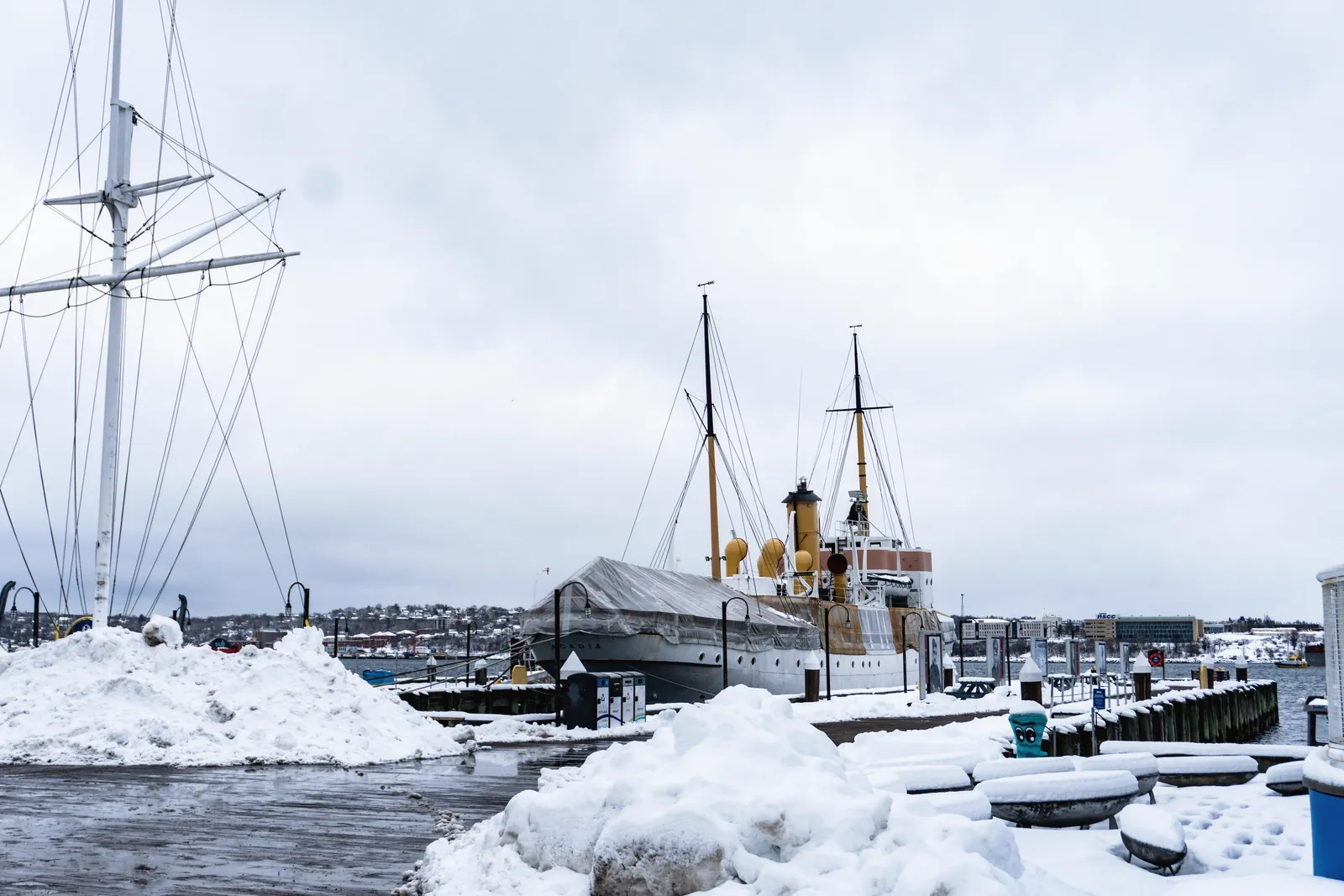 A historic ship docked in a snowy harbor on a cold winter day, showing a serene maritime view.