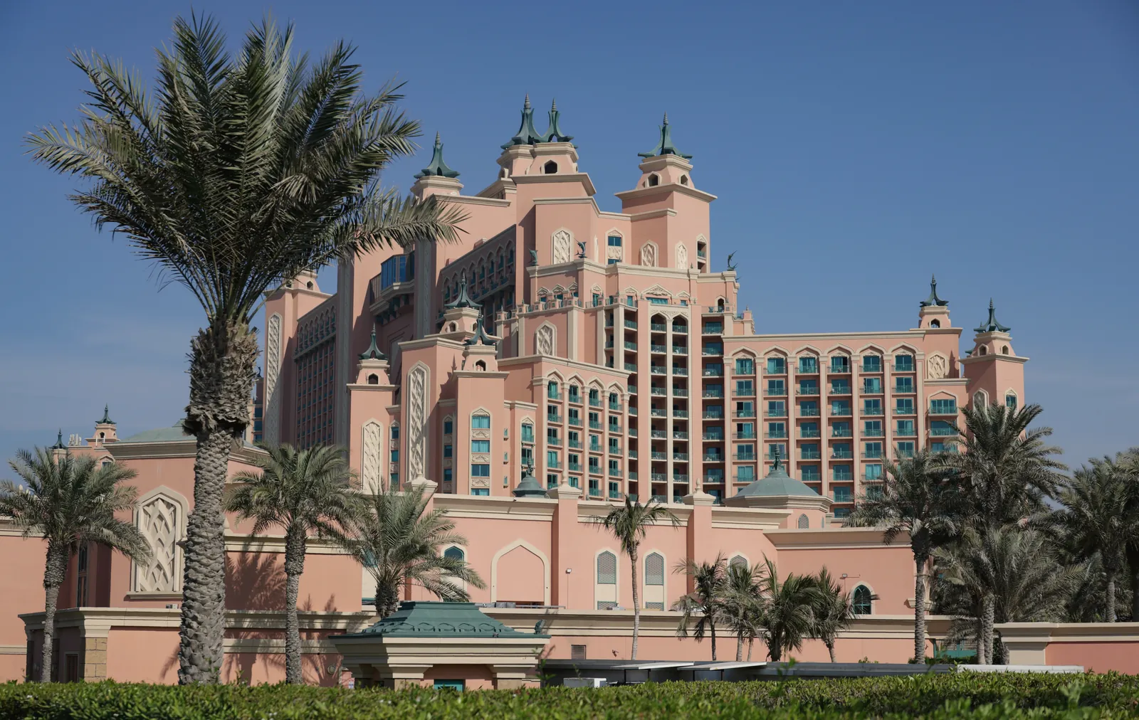 Majestic modern Atlantis hotel architecture with palm trees under a clear blue sky.