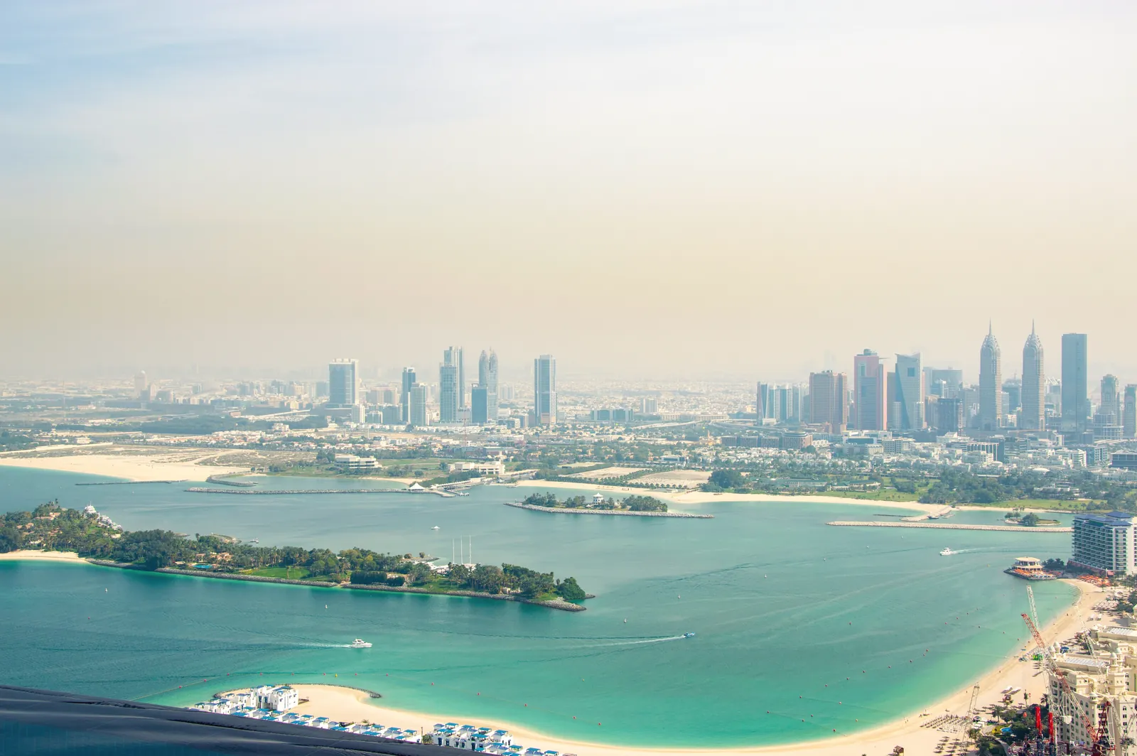 Stunning aerial view of Dubai's skyline with a beautiful coastline and clear blue waters.