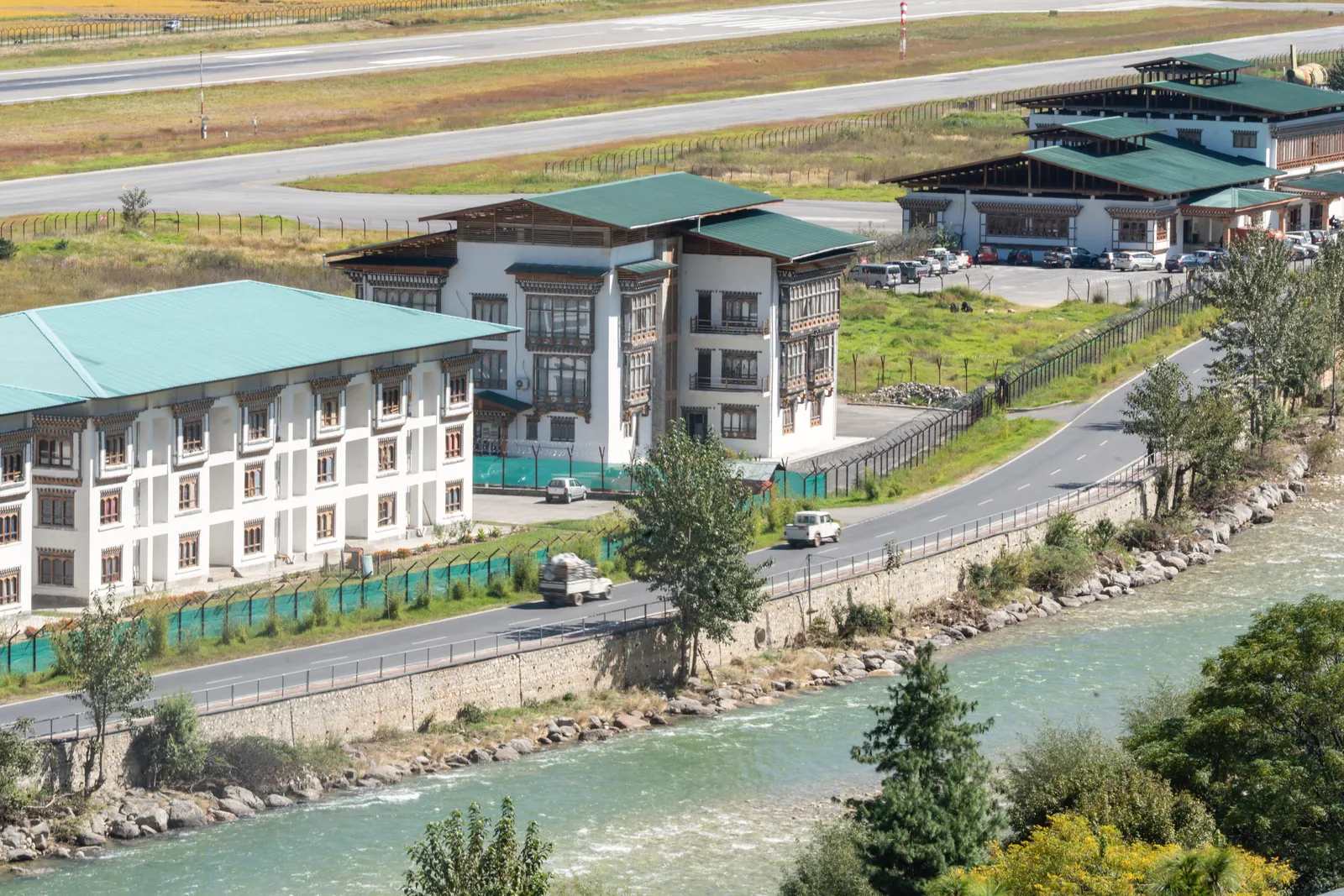 Scenic view of Bhutanese architecture along a river, capturing traditional design and natural beauty.