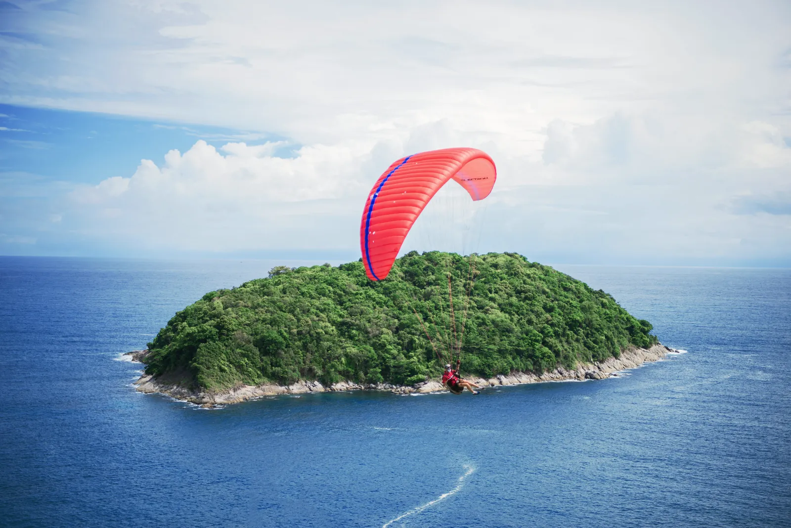 Experience an exhilarating paragliding adventure over lush Phuket island and clear blue waters.