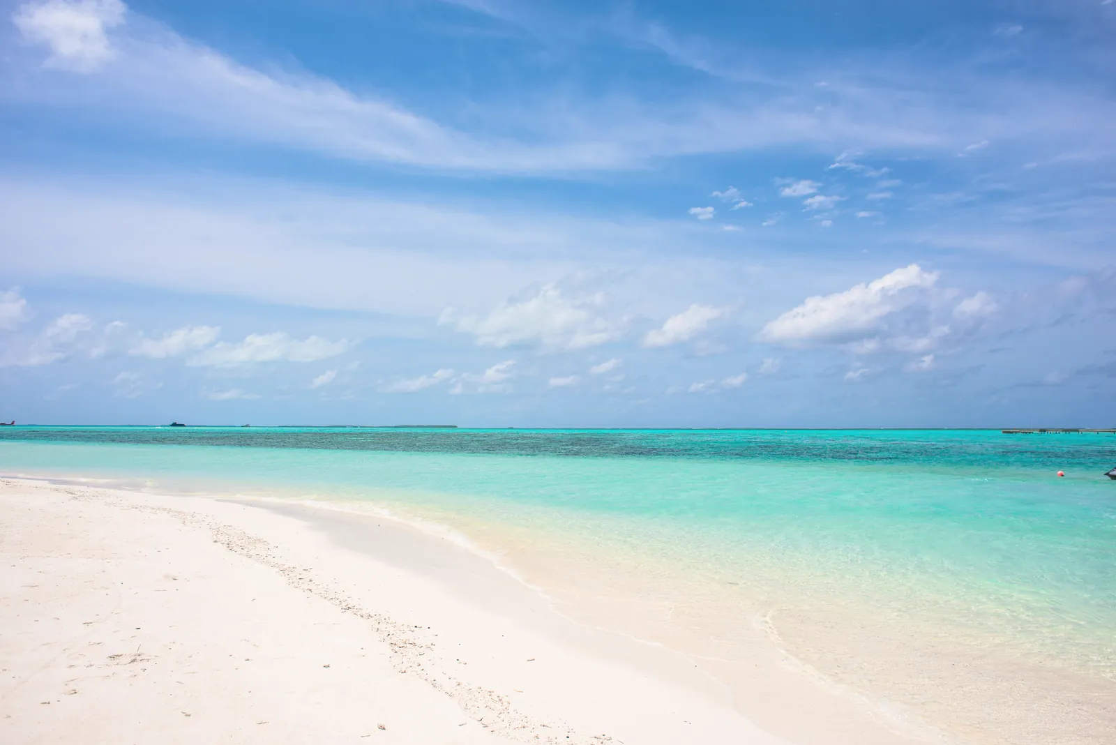 Pristine tropical beach with turquoise water and a clear blue sky, ideal for travel inspiration.