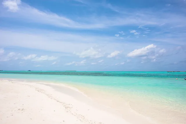 Pristine tropical beach with turquoise water and a clear blue sky, ideal for travel inspiration.