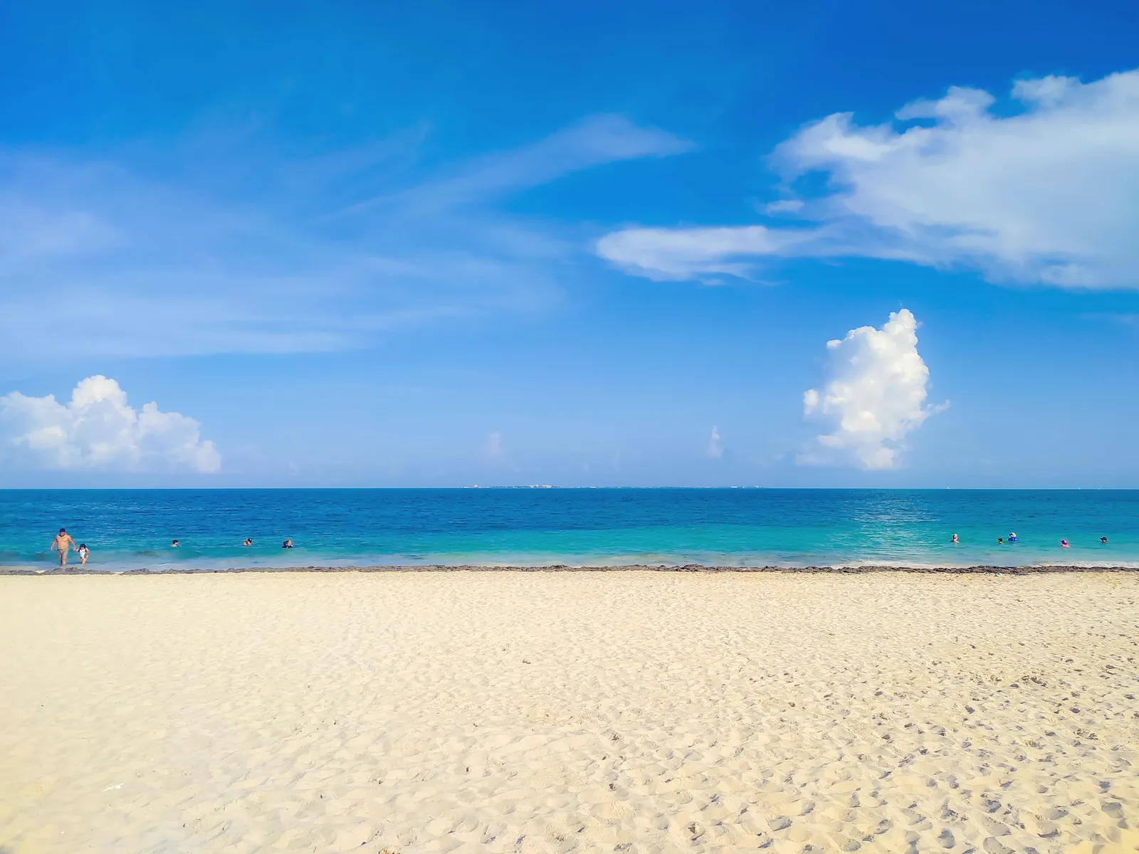 A beautiful sunny day at Cancún beach with turquoise ocean and clear blue skies.