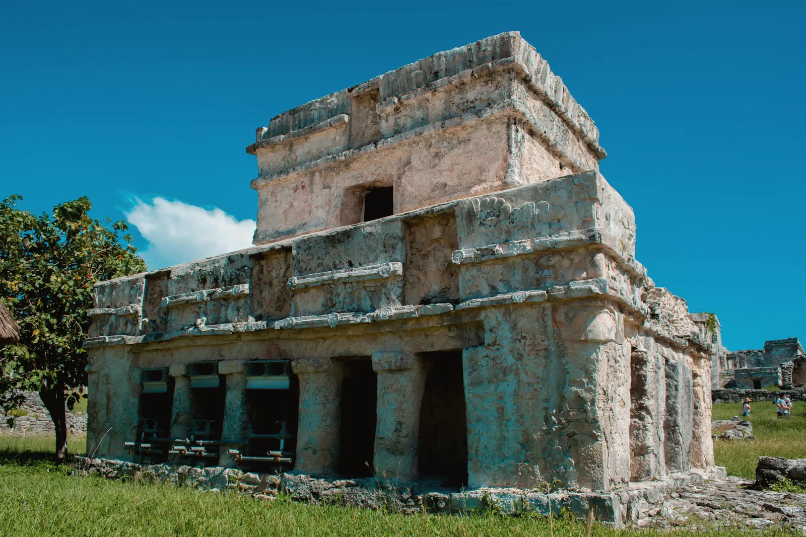 Explore the ancient ruins of Tulum, showcasing Mayan architecture under a bright blue sky.